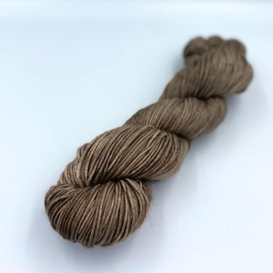 Skein of superwash merino yarn hand dyed in a tan color