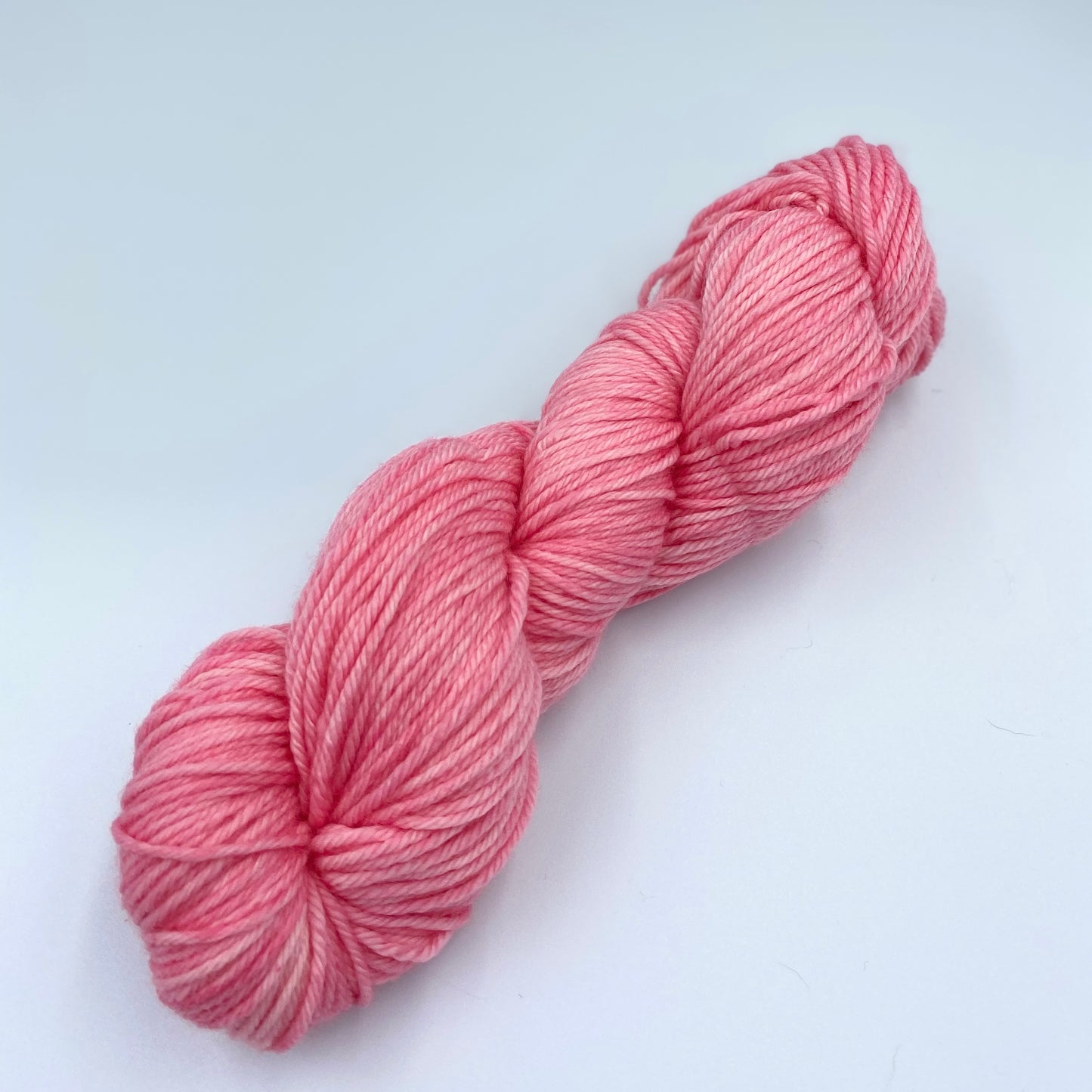 Skein of superwash merino yarn hand dyed in a baby pink color