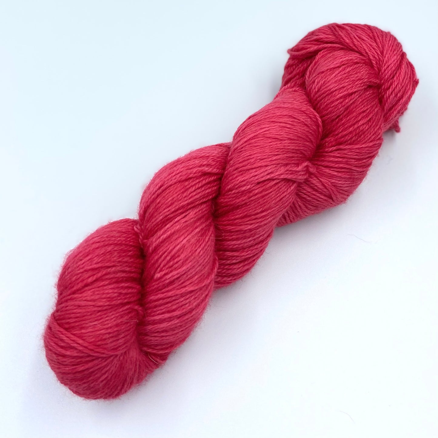 A skein of sparkly wool and nylon yarn hand dyed in the color red