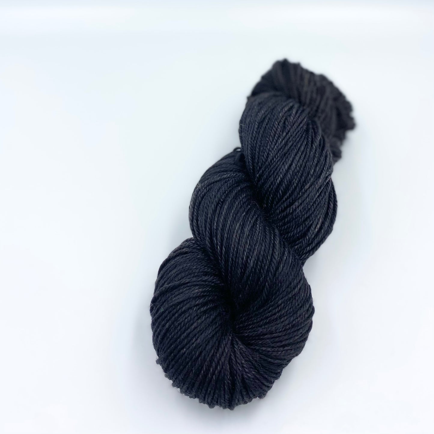 Skein of superwash merino yarn hand dyed in a navy color