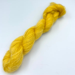 A skein of hand dyed kid mohair and silk yarn in a yellow corn  color 