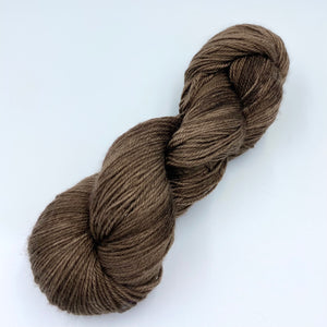 A skein of sparkly wool and nylon yarn hand dyed in the color teddy bear brown