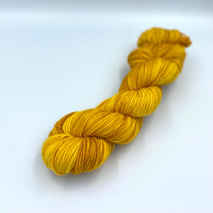 Skein of superwash merino yarn hand dyed in a sunshine like yellowcolor