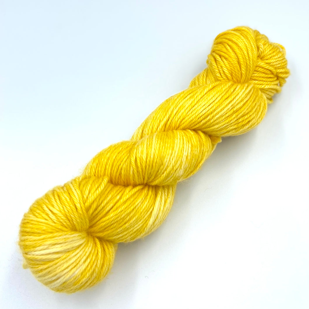 Skein of superwash merino yarn hand dyed in a yellow color